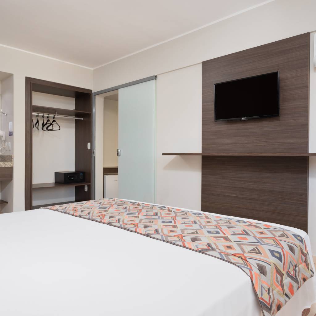 Cama, televisão e guarda-roupas Suíte Master King Size.